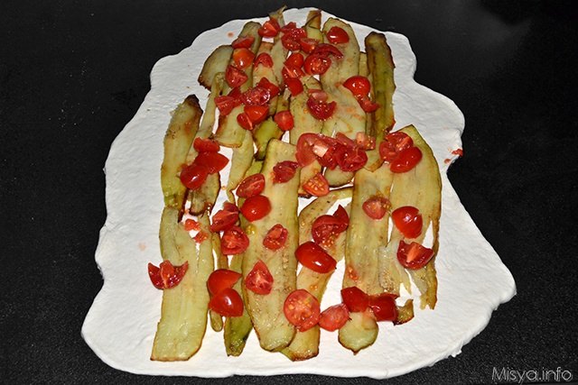 mettere al centro dell'impasto le fette di melanzane fritte ed i pomodori tagliati